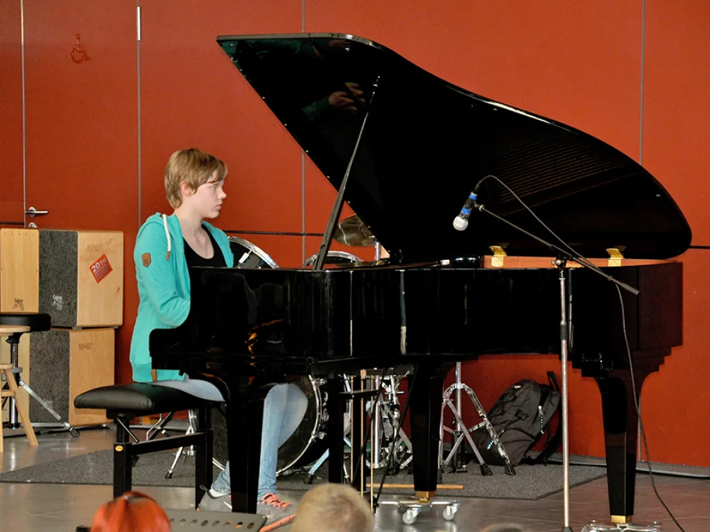 Eine Pianistin sitzt am Flügel auf der Bühne.